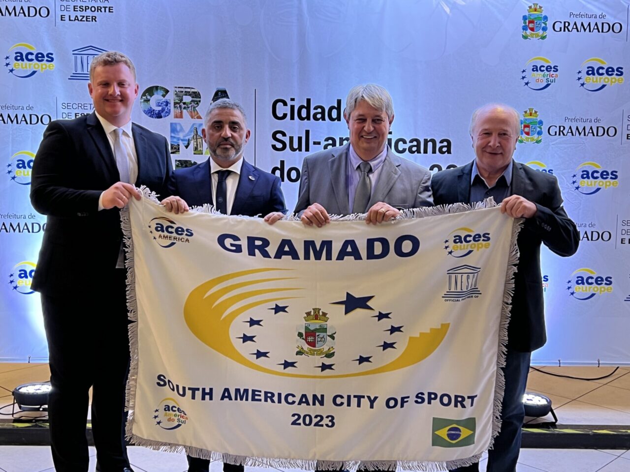 Lucas, Nuno, Nestor e Luia exibem a bandeira oficial do título.