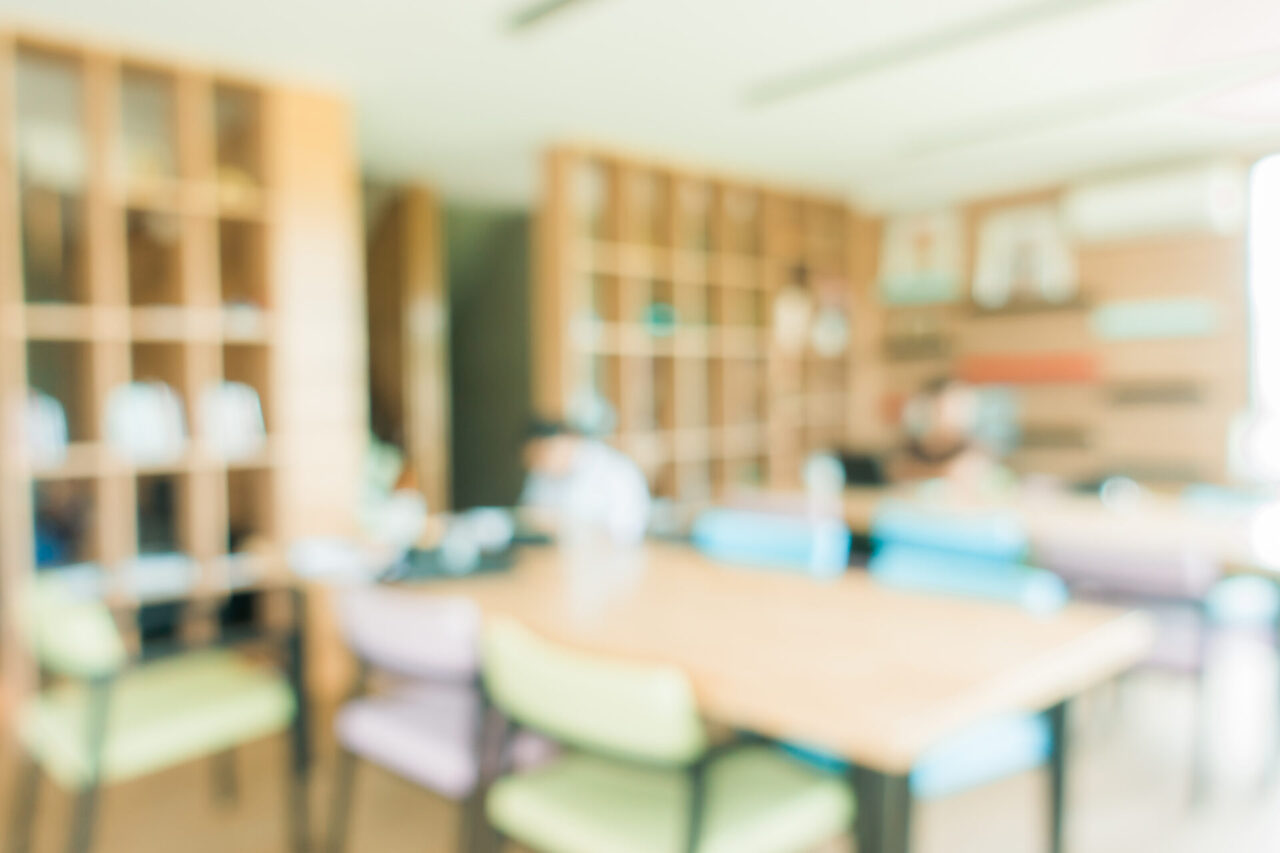 School classroom in blur background without young student; Blurry view of elementary room no kid or teacher with chairs and tables in campus. Vintage effect style pictures.